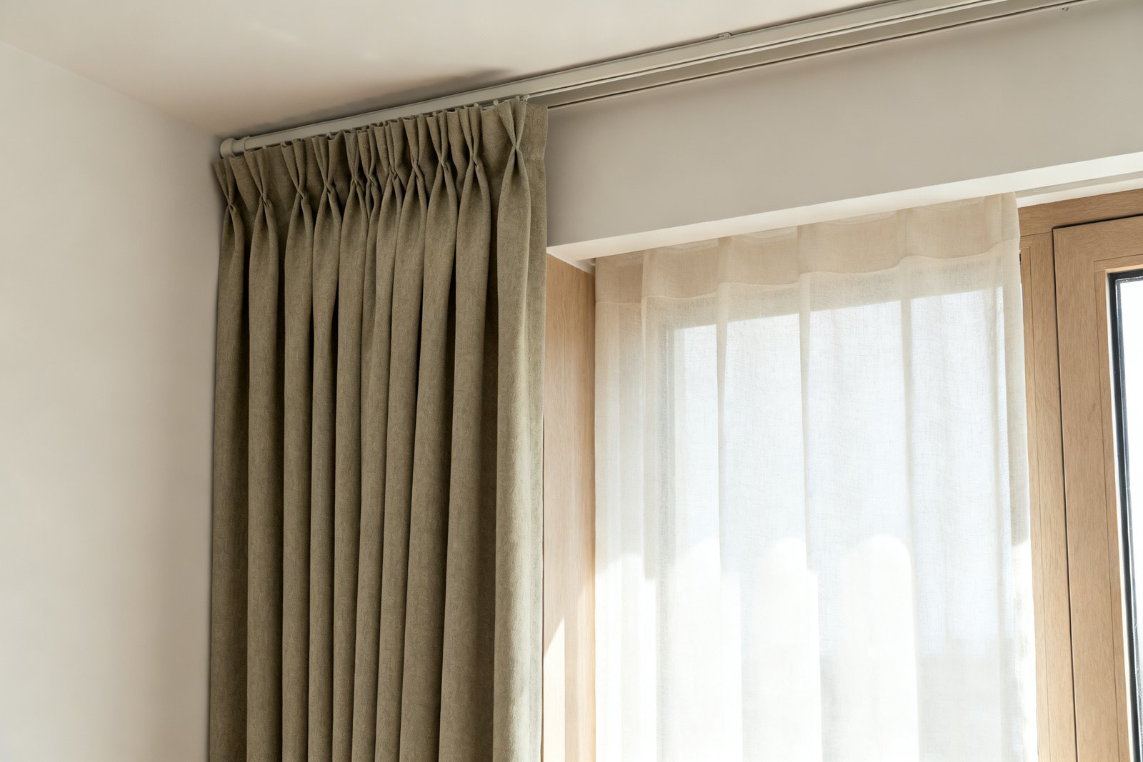 One window hung with two panels for comparison: a heavy lined pleated drape on the left, a light unlined translucent curtain on the right.